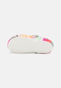 Des crocs colorés avec un motif tie-dye en rose, orange et vert. La semelle blanche texturée possède un motif de traction pour l'adhérence.