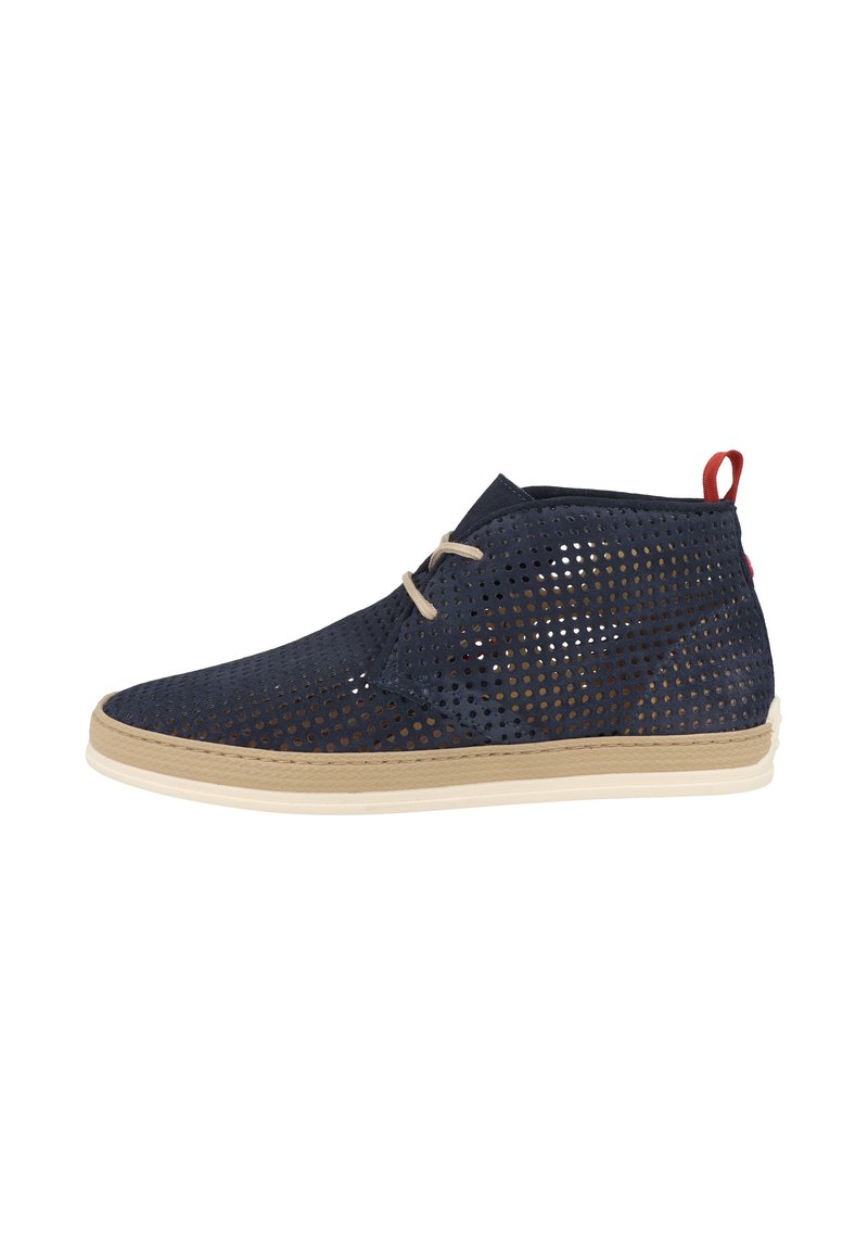 Scarpa traforata blu navy con suola beige, dotata di un tassello rosso sul tallone e lace beige. Design a metà caviglia con finitura testurizzata.