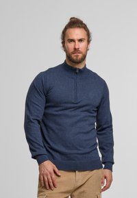 Marinblå pulloversweater i mjukt tyg, med en zippered krage, ribbade cuffs och nederkant, med en åtsittande passform och slät textur.