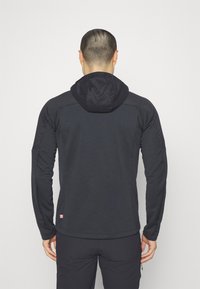 Black hooded jacket with a smooth exterior and textured panels on shoulders. Features long sleeves and a logo patch near the hem.
