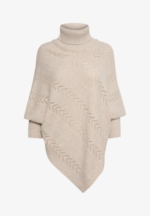 Poncho beige en tricot avec col haut. Présente des motifs en côtes diagonales et des découpes en zigzag le long du tissu.