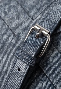 Denim-Tasche Riemen in Blautönen, mit einer strukturierten Oberfläche, silberner Metall-Schnalle und verstellbaren Löchern zur Größenanpassung.