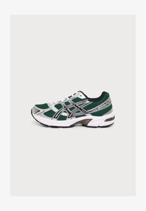 Chaussure de course verte et argentée avec semelle blanche et accents noirs, en tissu mesh avec détail du logo latéral, présentée de profil sur un fond uni.