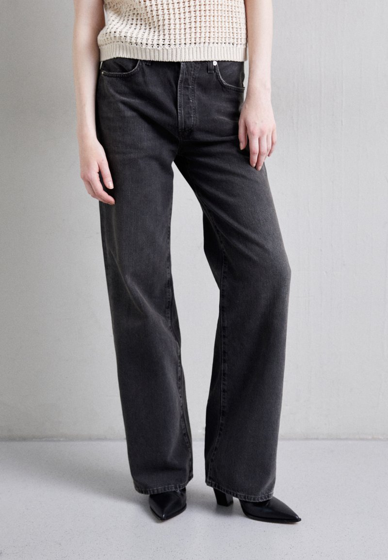 Gray wide-leg jeans made of denim, featuring a high waist, classic five-pocket design, and subtle faded texture. Pairing with pointed black heels.