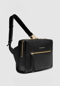 Borsa a tracolla in pelle nera con dettagli in metallo color oro, compartimento principale con cerniera e tasca frontale con cerniera. Dotata di cinturino regolabile e finitura testurizzata.