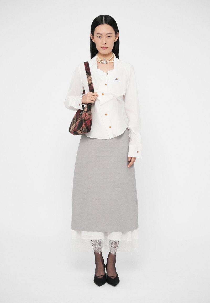 Hvid button-down skjorte med orange knapper, grå nederdel, blondeaccents, sorte hæle og en ternet skuldertaske.