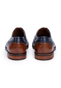 Chaussures en cuir marron avec un dessus bleu marine, bout rond et dos texturé. Comprend un talon marron et une semelle marron foncé avec des détails de couture.