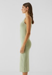 Robe ajustée vert clair en coton, avec un col rond et une longueur au genou. Texture lisse, sans motifs ni accents visibles.
