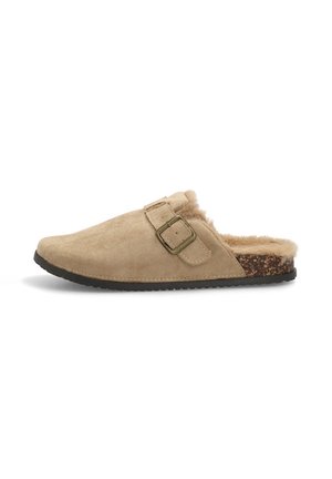 Zapato slip-on de ante beige con forro de pelo sintético, hebilla ajustable y plantilla texturada marrón. Suela de goma para mayor durabilidad.