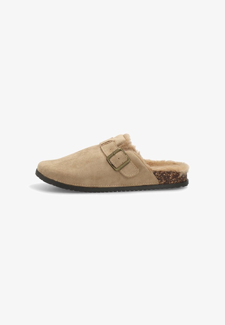 Zapato slip-on de ante beige con forro de pelo sintético, hebilla ajustable y plantilla texturada marrón. Suela de goma para mayor durabilidad.