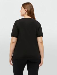 Tricou negru cu mânecă scurtă realizat dintr-un material de bumbac moale, având o croială lejeră, decolteu rotund și o textură fină.