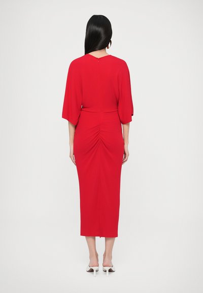 Sarkana, pieguloša pusgaruma kleita ar plūstošām piedurknēm, savilkuma detaļu aizmugurē un rāvējslēdzēju aizmugurē. Gluda tekstūra, lieliski sader ar baltām augstpapēžu kurpēm.