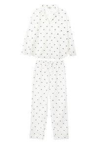 Weißes Pyjama-Set mit einem langärmligen Hemd mit Knopfleiste und passenden Hosen, beide mit kleinen, bunten Herzmustern verziert.