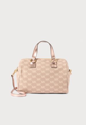Beżowa torba typu satchel z monogramem MK, podwójnymi górnymi uchwytami, złotym okuciem, zamkiem błyskawicznym i odpinanym paskiem na ramię.