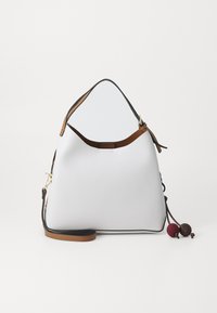 Sac à main en cuir blanc avec une forme de hobo décontractée, des accents marron, des garnitures noires et des pompons décoratifs en rouge foncé et marron. Bandoulière réglable.