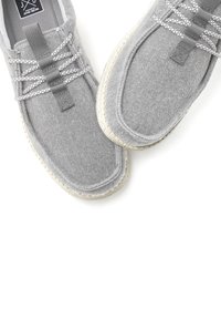 Graue Leinenschuhe mit weicher Textur, ausgestattet mit elastischen Schnürsenkeln, einer Gummisohle und dezenten Nähten am Rand.