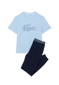 T-shirt en coton bleu clair avec un logo crocodile géométrique bleu marine, associé à un pantalon bleu marine avec une ceinture à motif.