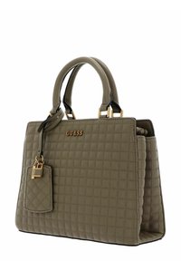 Borsa a tracolla trapuntata color beige con hardware dorato, due manici e un'etichetta removibile. Texture liscia con forma strutturata, che mostra un sottile motivo a griglia.