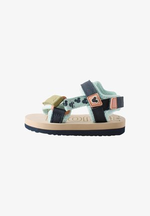 Sandale pour enfant verte et bleu marine avec des sangles réglables, semelle en caoutchouc et dessus texturé. Présente un motif de Mickey Mouse et des accessoires décoratifs.