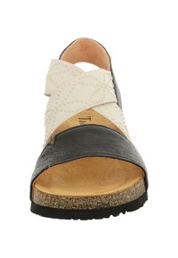 Schwarzer und cremefarbener Sandale mit einem Kreuzriemendesign, aus Leder und strukturiertem Stoffmaterial, mit beigem Fußbett und einer korkähnlichen Sohle.