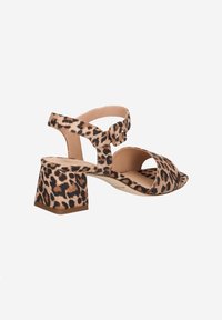 Leoprint Hohe Absatzsandalen mit offener Zehe, breiten Riemen, Knöchelunterstützung und einem klobigen Blockabsatz. Das Material scheint weich und strukturiert zu sein.