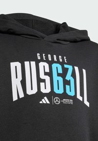 Sudadera negra con gráfico en blanco y turquesa que dice "GEORGE RUS63LL" junto a los logotipos de adidas y Mercedes AMG Petronas. Textura de tejido suave.