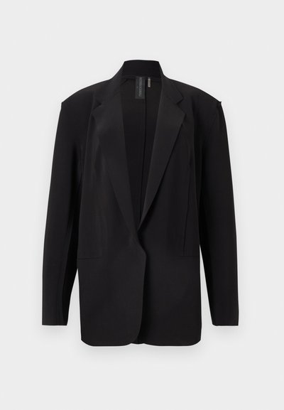 Μαύρο υπερμεγέθες μπλέιζερ με notch πέτο, μακρυά μανίκια και ανοιχτό μπροστινό μέρος, παρουσιασμένο σε λευκό φόντο.