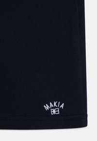 Námornícke tričko vyrobené z mäkkej bavlny s rebrovanou štruktúrou, s vyšívaným bielym logom "MAKIA" na spodnom leme.
