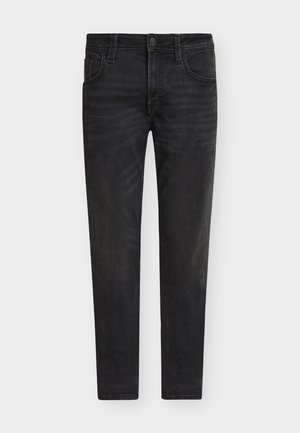 Vaqueros pitillo negros de mezclilla con botón frontal, trabillas para cinturón y diseño de cinco bolsillos, mostrados sobre un fondo blanco.