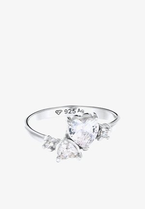 Anillo de plata con gemas transparentes en forma de corazón, una grande y una más pequeña, acentuadas por pequeñas piedras redondas. Marcado "925 Ag" en el interior de la banda.
