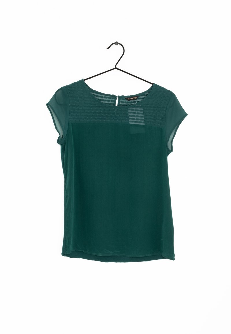 Blouse vert foncé à manches courtes avec panneau supérieur et manches transparentes, suspendue sur un cintre noir sur un fond blanc.