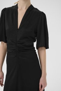 Black dress with a deep V-neck, short puff sleeves, and gathered detailing at the waist. The fabric has a subtle textured pattern.