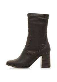 Braune Leder-Stiefelette mit spitzer Zehenform, elastischen Seitenrastern und einem strukturierten Blockabsatz. Nahtdetails entlang der oberen Kante.