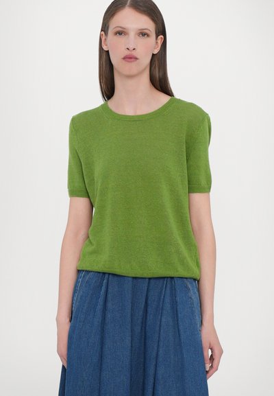 Groen shirt met korte mouwen, gemaakt van lichtgewicht materiaal en met een ronde hals. Heeft een gladde textuur en een ontspannen pasvorm. Gecombineerd met een denimrok.