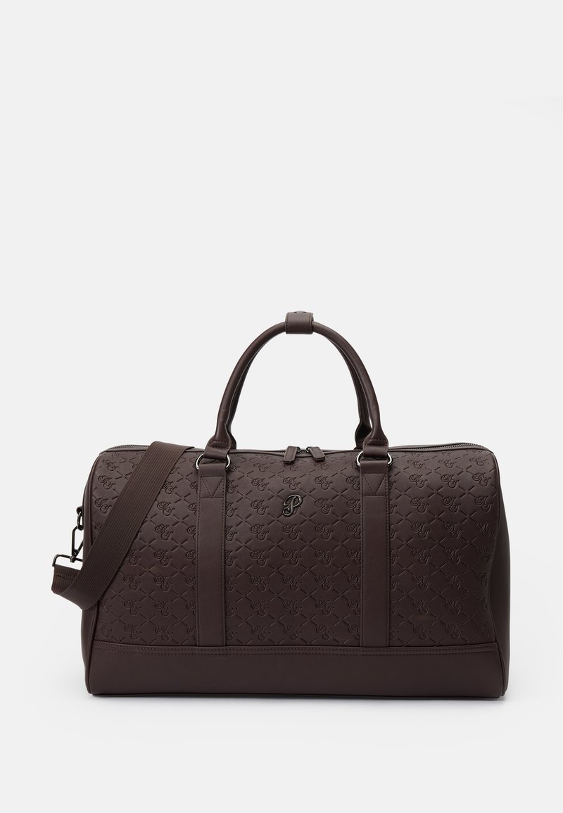 Brown duffel bag made of textured leather featuring dual handles and an adjustable strap. It has a subtle embossed logo pattern.