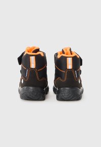 Svarta och orange utomhusskor med hög design, kardborreband, vadderad orange foder och texturerade gummisulor för grepp.