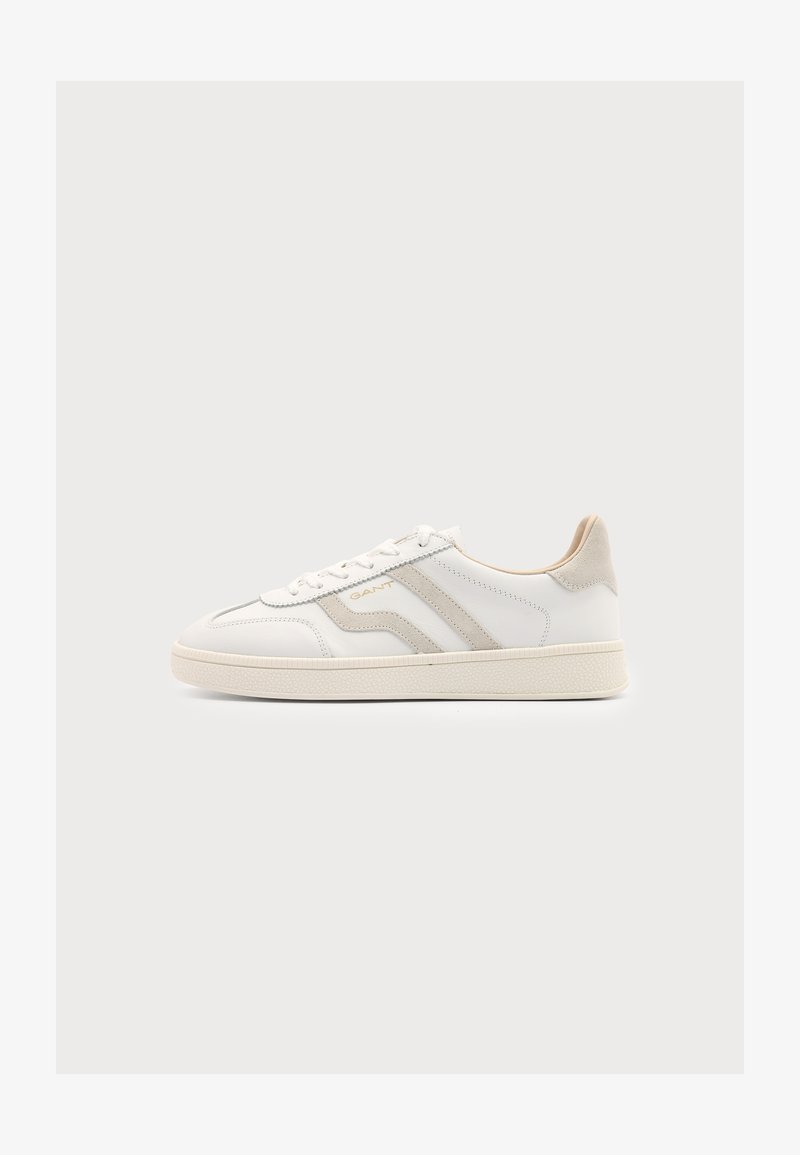 Baskets basses blanches avec des accents en daim beige, fermeture à lacets, semelle texturée et logo GANT sur le côté.
