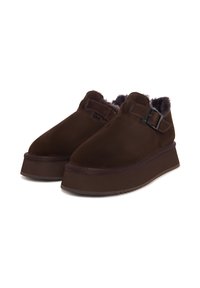 Bruine schoenen met een zacht suède bovenwerk, een gevoerde binnenkant, een dikke platformzool en een verstelbare gespdetail aan de zijkant.