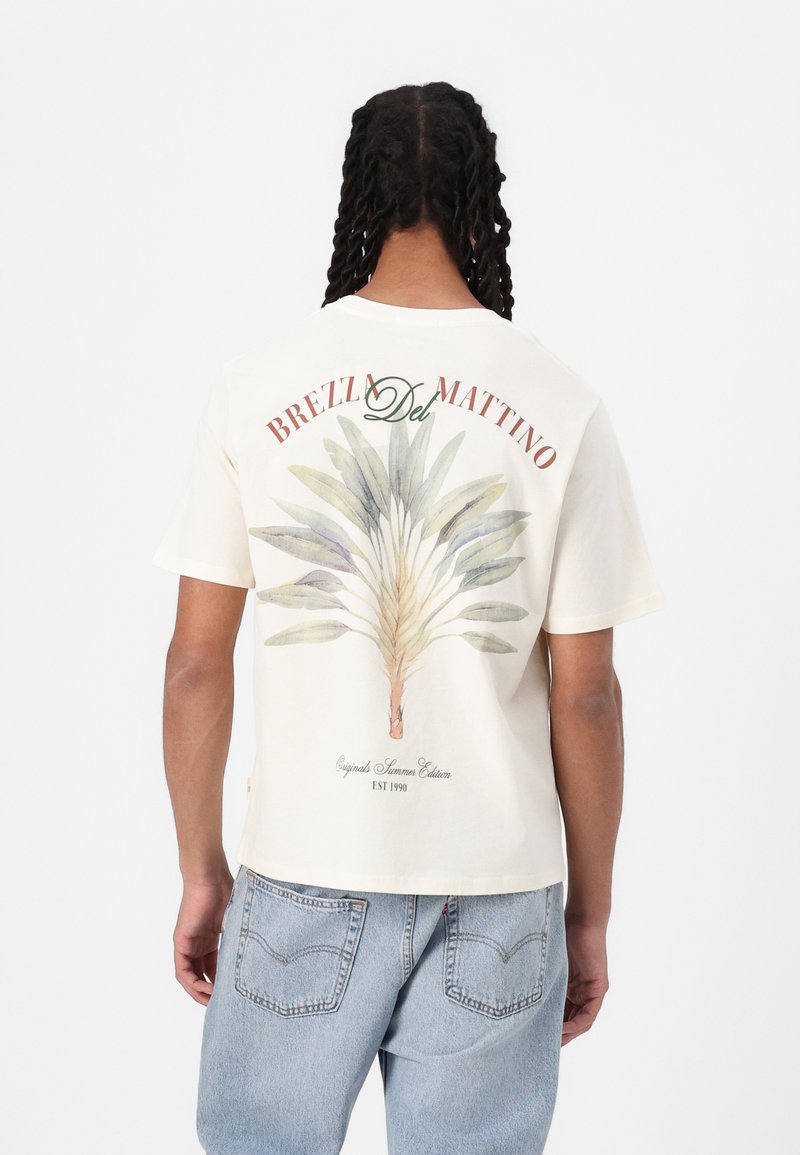 Short-sleeve cream t-shirt featuring a green and blue leaf design on the back, with red text reading "BREZL Del MATTINO" above it.