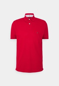 Paita polo punainen valmistettu puuvillasta, jossa on yksivärinen muotoilu. Varusteena kaulus, kahden napin listaa ja pieni logo rinnassa.