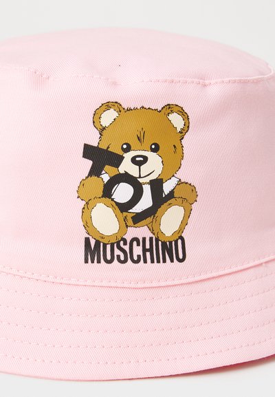 Rosa Bucket Hat aus glattem Stoff mit einem Cartoon-Bären-Design, der das Wort "TOY" hält, und dem Markennamen "MOSCHINO" darunter.