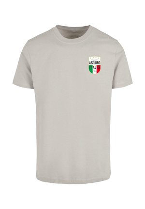 Svetlo siva bombažna majica z logotipom ščita, na katerem so napisani besedi "AZZURRO" in "ITALIA" v zeleni in rdeči barvi, obkroženi z dekorativnimi zvezdami.