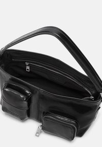 Bolso de mano de cuero negro con un acabado liso, que cuenta con dos bolsillos exteriores con cremallera y un interior espacioso. Asa duradera para un fácil transporte.