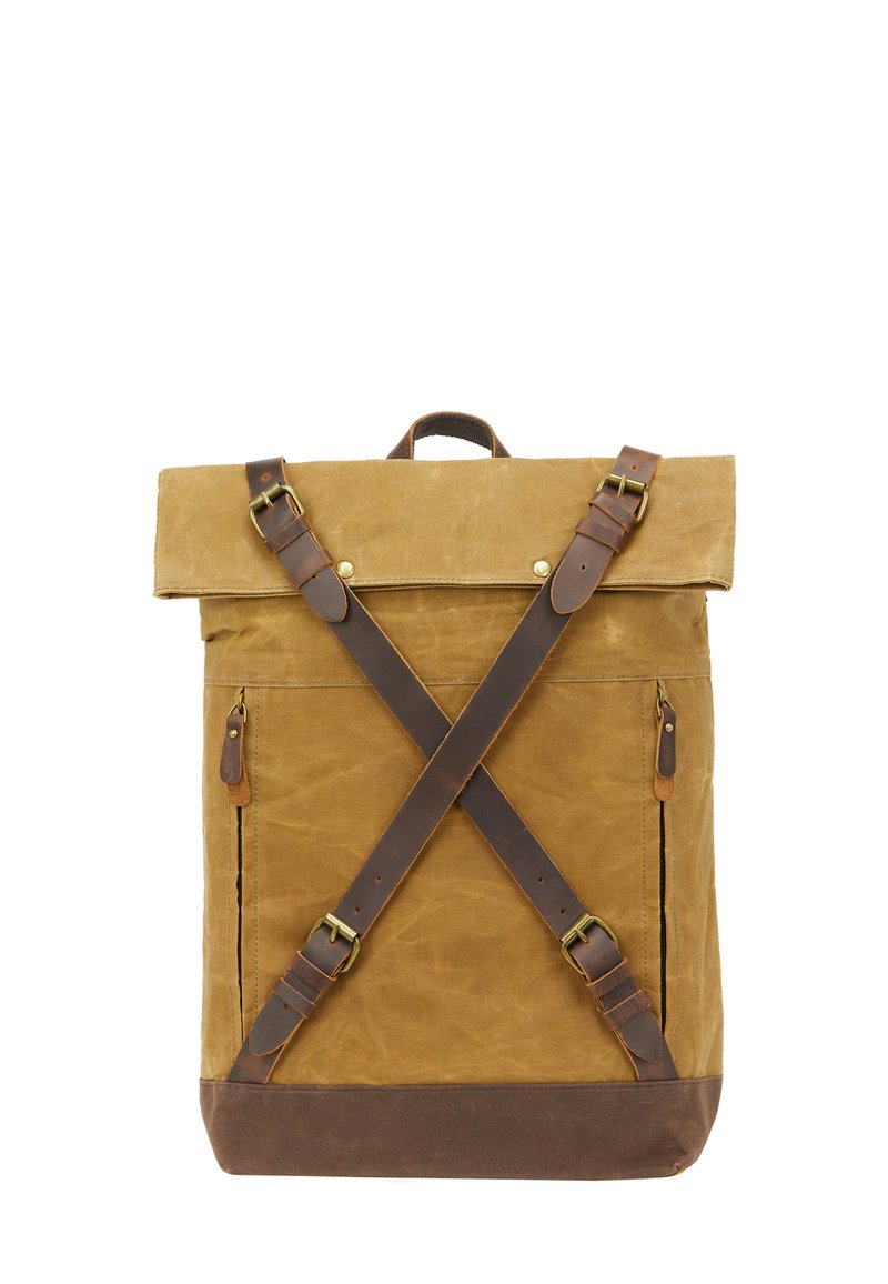 Beige canvas ryggsäck med bruna läderdetaljer, utrustad med rull-up design, mässingshårdvara och korsbanddetaljer på framsidan.