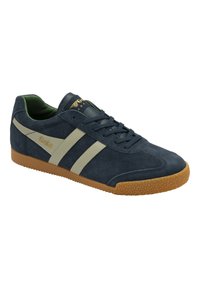Sneaker in suede blu navy con strisce beige, suola in gomma testurizzata, punta rotonda e occhielli rinforzati. Presenta il logo sulla linguetta e sul lato.