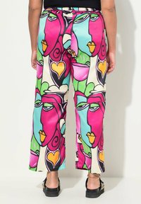 Kleurrijke, gestreepte broek met abstracte gezichten in roze, groen, blauw en geel. Gemaakt van een soepele stof met een elastische tailleband.