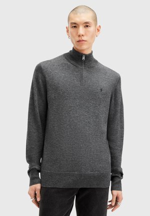 Dunkelgrauer Sweater mit Reißverschluss am Hals, hergestellt aus einem weichen Stoff, mit langen Ärmeln und geripptem Saum. Kleines Logo auf der Brust, glatte Textur.