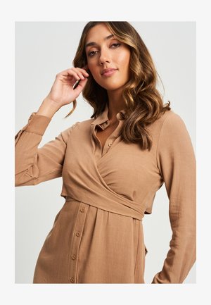 Vestido envolvente marrón con mangas largas, detalles de botones y cintura ajustada. Textura suave con un brillo sutil, que presenta un cuello y puños puntiagudos.