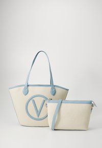 Two bags: a large cream tote with a blue leather trim and a circular logo, and a smaller cream pouch with a detachable blue strap.