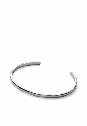 Tynd, let buet sølv åben armring med en glat, poleret overflade på en hvid baggrund.